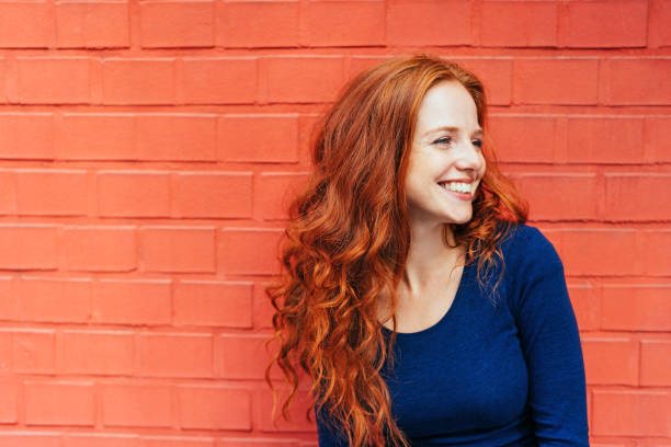 Happy woman with red hair looking to the side stock photo