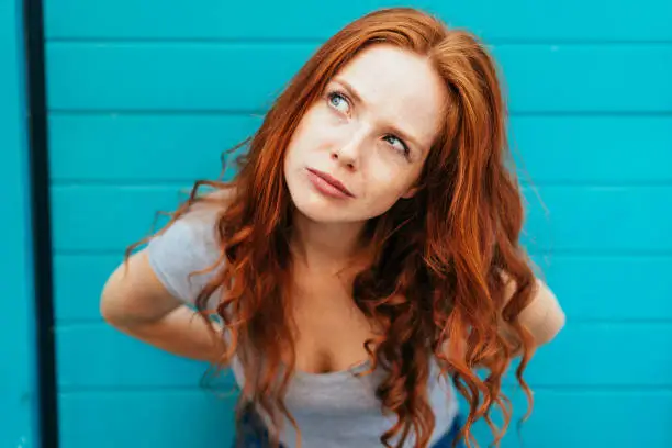 Photo of Thoughtful attractive redhead woman