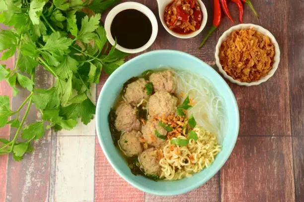 Bakso, famous traditional Indonesian street food, meatballs with noodles served with sambal, soy sauce and fried shallot