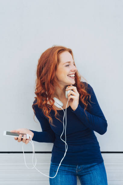 istock Laughing woman looking to side while holding phone 1071327926