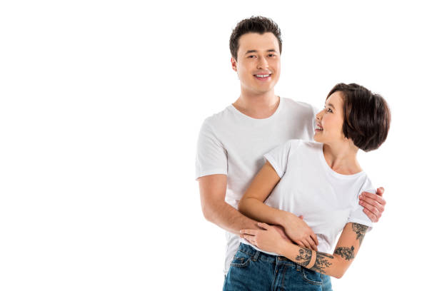istock smiling boyfriend hugging girlfriend and looking at camera isolated on white 1071330706