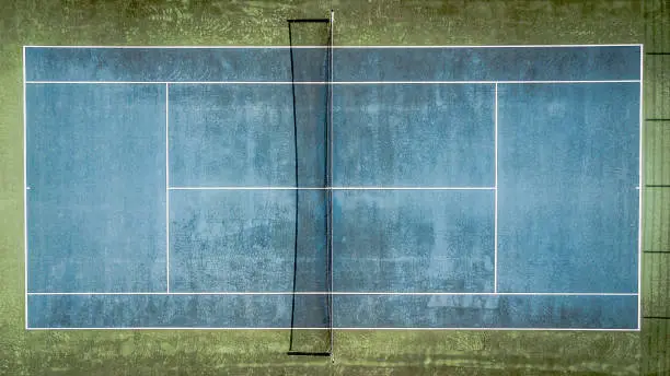 Photo of Top view of a blue old tennis court.