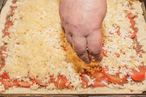 istock Cooking pizza pie with meat and vegetables under cheese 1071332830