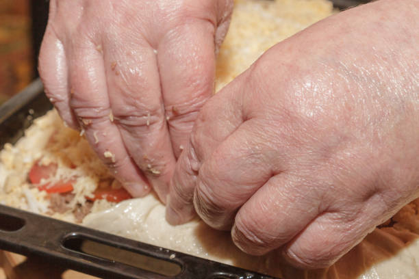 istock Cooking pizza pie with meat and vegetables under cheese 1071332860