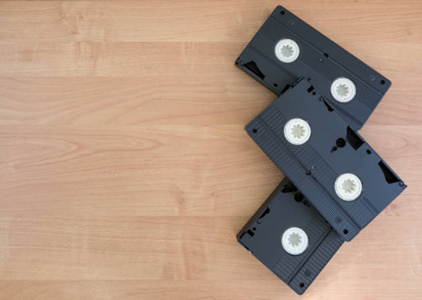 istock 3 black VHS with white spoons lying on a beige wooden background with copy space. 1071332956