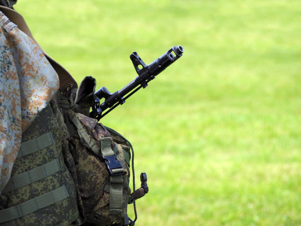istock Shooting weapon, special operations forces combat. Army soldier with assault rifles and in bulletproof vests are on natural green military background 1071343166