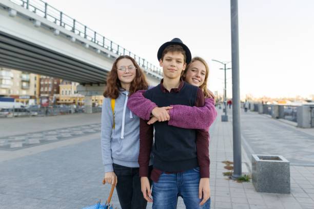 portrait de la ville extérieure de trois amis adolescents garçons et filles 13, 14 ans - friendship early teens 13 14 years city street photos et images de collection