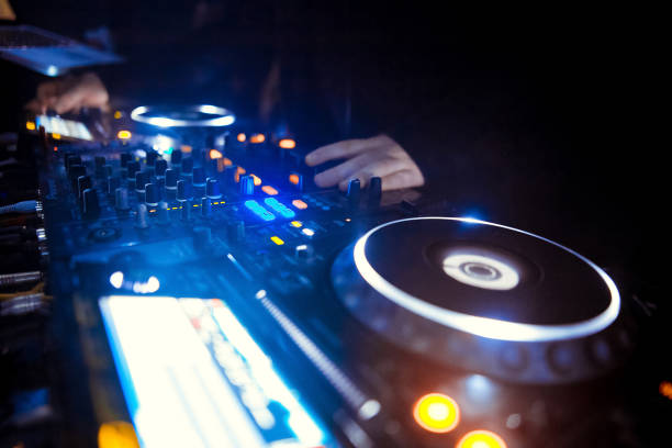 istock DJ turntable console mixer controlling with two hand in concert nightclub stage. 1071353898