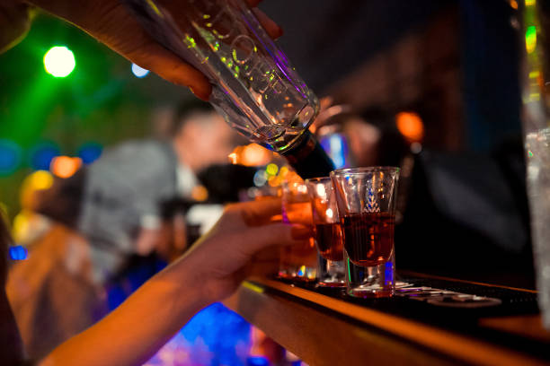 Bartender pours alcoholic cocktails.