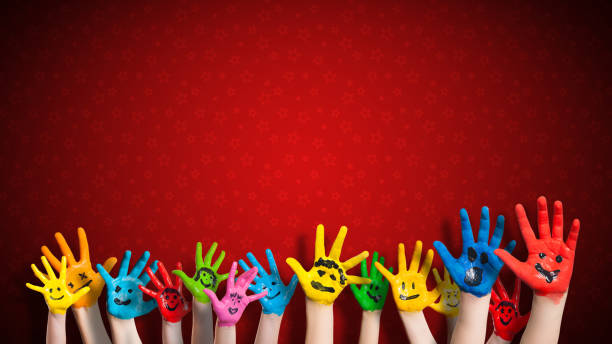 istock painted children hands with smiley in front of christmas background 1071364672
