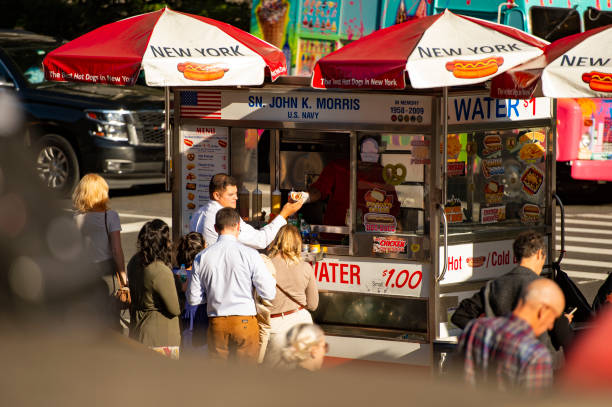 alcuni turisti acquistano hot dog da un chiosco a times square. - 6th street foto e immagini stock