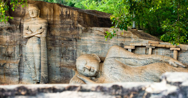 (selective focus) The beautiful statue of Reclining Buddha and Monk Ananda, Gal Viharaya, Polonnaruwa, Sri Lanka. (selective focus) The beautiful statue of Reclining Buddha and Monk Ananda, Gal Viharaya, Polonnaruwa, Sri Lanka. anuradhapura stock pictures, royalty-free photos & images
