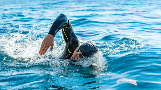 nuotatore in acque libere che nuota in mare - sporting position vitality blurred motion strength foto e immagini stock