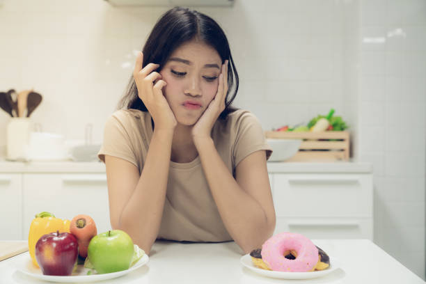 Young beautiful woman are restraint her mind to refrain from eating it are high in fat and calories to health care stock photo