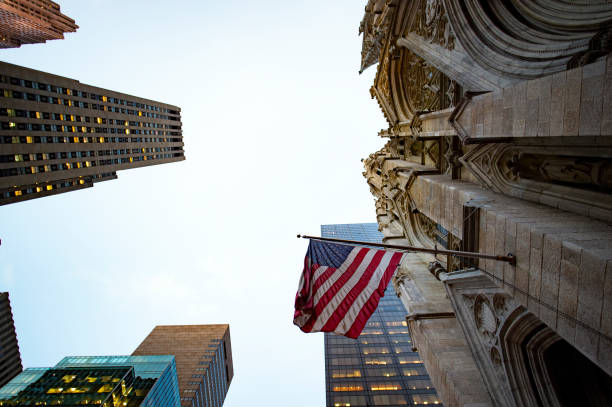 una bandiera americana sventola su una chiesa di manhattan. - wall street finance stock market power foto e immagini stock