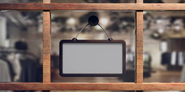 istock Blank sign with wooden frame hanging on glass storefront, copy space. 3d illustration 1071380560