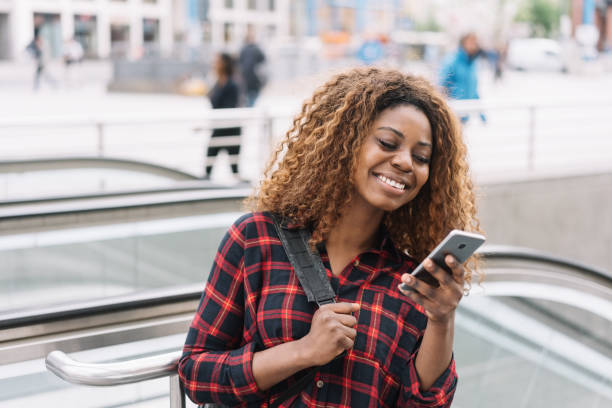 istock Young cheerful black woman using mobile phone 1071382520