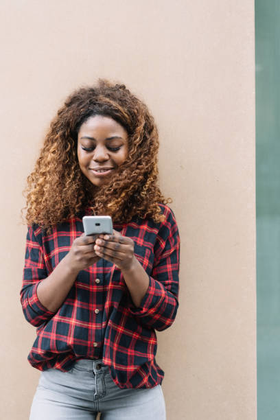 istock African American smiling woman using mobile phone 1071382802