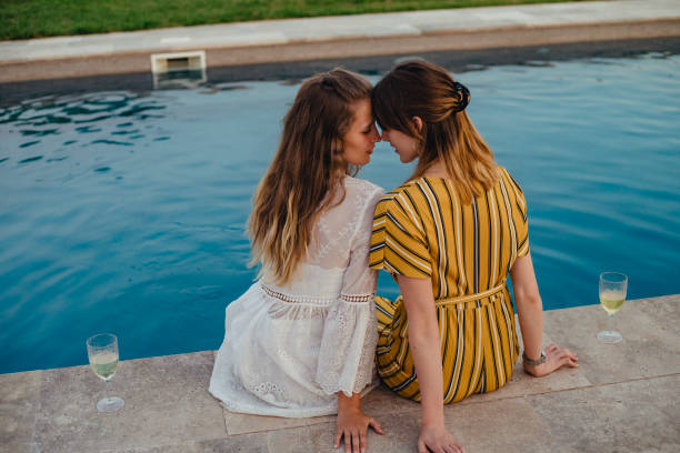 istock Lesbian Couple Sitting by the Swimming Pool 1071382876