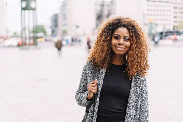 istock Smiling African woman walking through town 1071383836