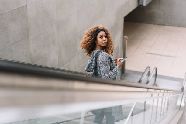 istock Young African woman riding a subway escalator 1071383958