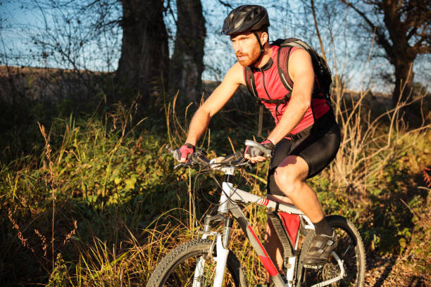 istock Determined young bearded man riding mountain bike along a path through forest 1071389090