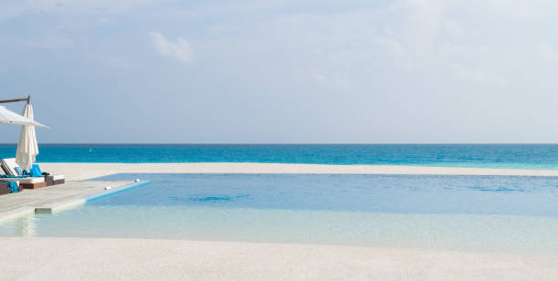 istock Deck chairs and infinity pool over amazing tropical lagoon in Maldives 1071389298