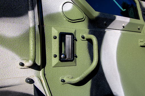 Handle for opening an armored military truck to suppress aggression, close-up of a closed lock with a flap for firearms.
