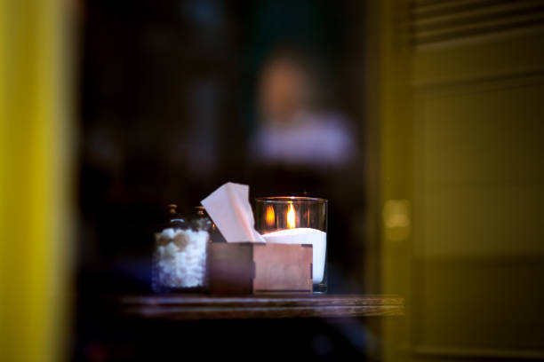 Hands wrapped around a large candle close-up, copy space