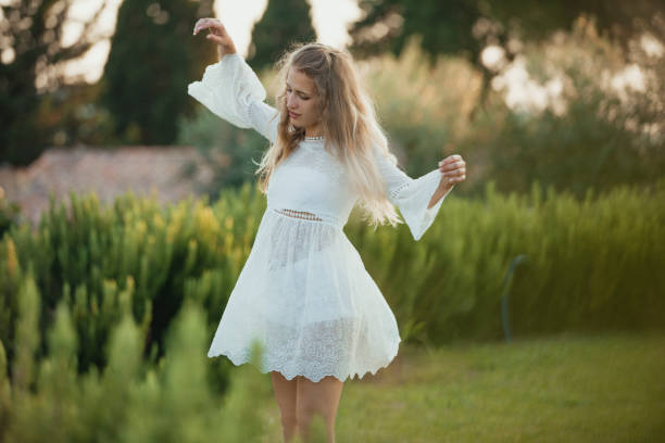 Young female dancing around alone in a Tuscan field