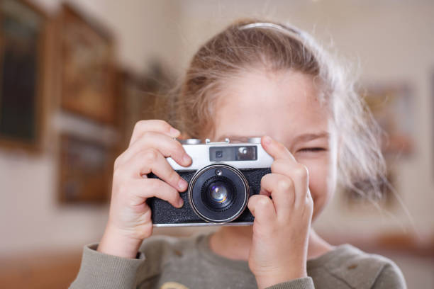 istock Girl with a retro camera makes a photo. 1071395518