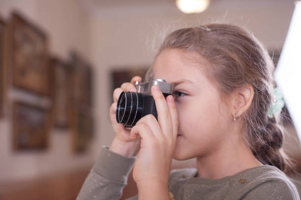 istock Girl with a retro camera makes a photo. 1071395530
