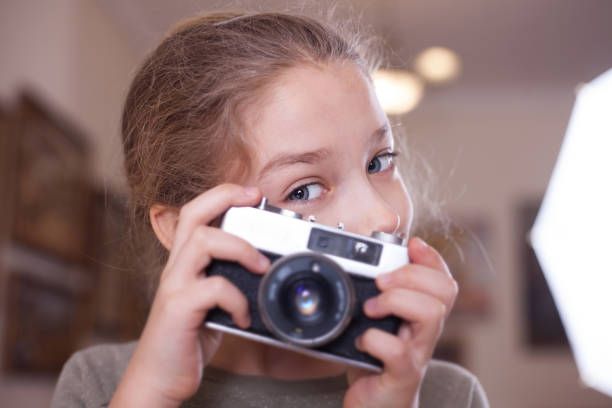 istock Girl with a retro camera makes a photo. 1071395538