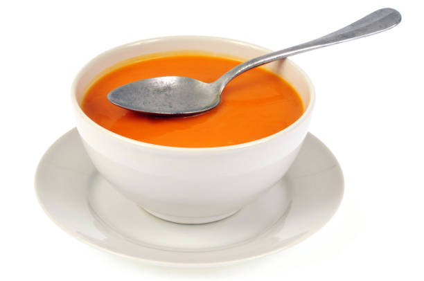 Bowl of pumpkin soup on a white background