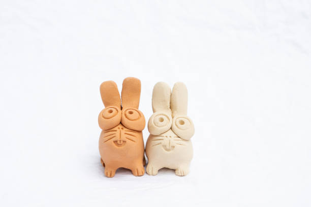 Design rabbit red and white clay sculpture on white background, natural material handmade toy