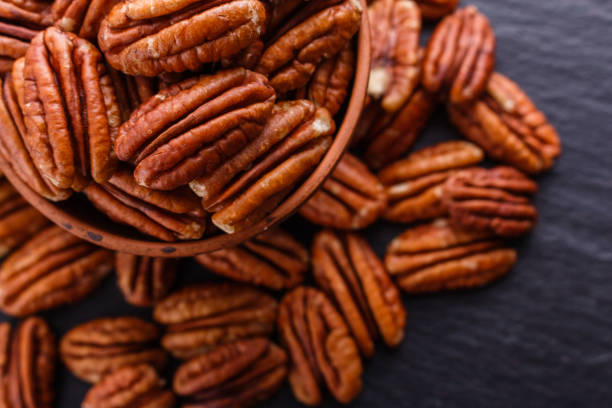 istock delicious pecan nuts on a dark stone background 1071401886