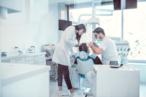 Dentist And Assistant Preparing Patient For Surgery Procedure