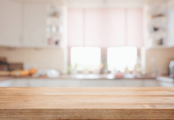 hölzerne tischplatte über defokussierten küche hintergrund - bauholz brett fotos stock-fotos und bilder