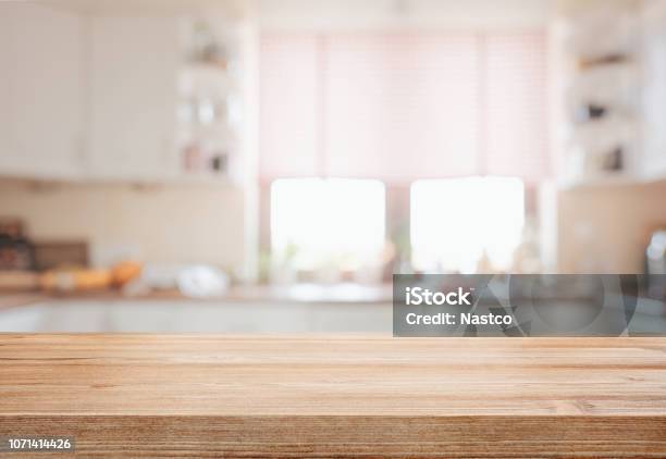 Wooden Tabletop Over Defocused Kitchen Background Stock Photo - Download Image Now - Kitchen, Table, Backgrounds
