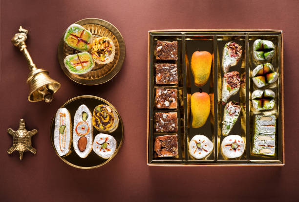 Indian sweets and Mithai in a box and a plate. Diwali festival concept, flat lay, top view Indian sweets and Mithai in a box and a plate. Diwali festival concept, flat lay, top view mithai stock pictures, royalty-free photos & images