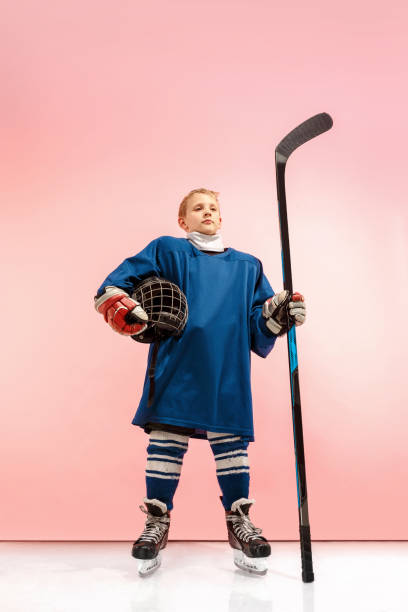a hockey player with equipment over a pink background - ice hockey roller hockey child childhood imagens e fotografias de stock