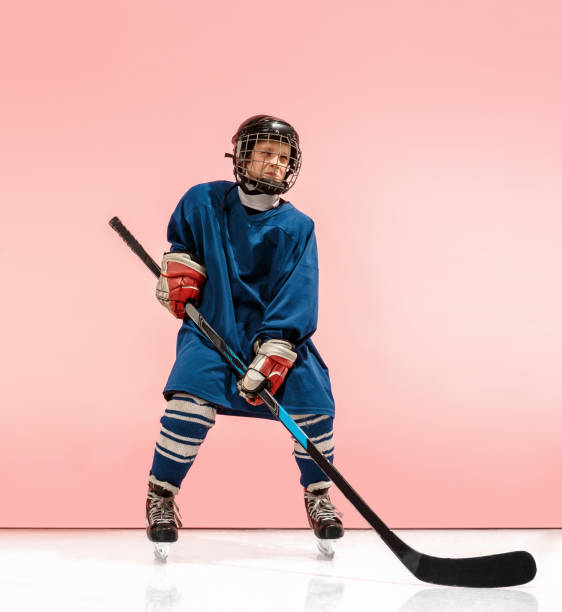 a hockey player with equipment over a pink background - ice hockey roller hockey child childhood imagens e fotografias de stock