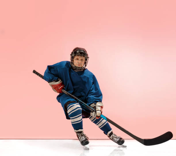 a hockey player with equipment over a pink background - ice hockey roller hockey child childhood imagens e fotografias de stock