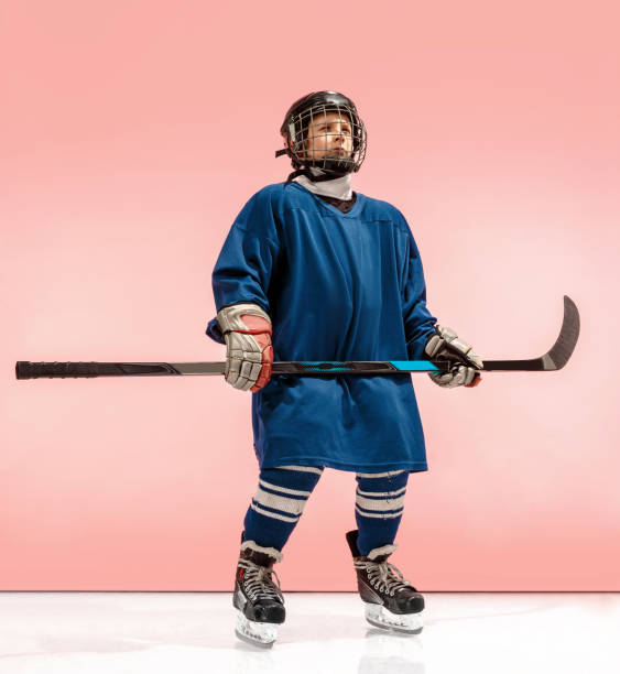 a hockey player with equipment over a pink background - ice hockey roller hockey child childhood imagens e fotografias de stock