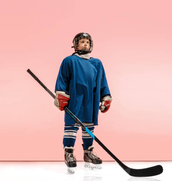 a hockey player with equipment over a pink background - ice hockey roller hockey child childhood imagens e fotografias de stock