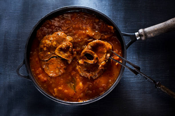 Osso Buco Veal Shanks Prepared with tomatoes, carrots and onions in a cast-iron pan Osso Buco Veal Shanks Prepared with tomatoes, carrots and onions in a cast-iron pan ossobuco stock pictures, royalty-free photos & images