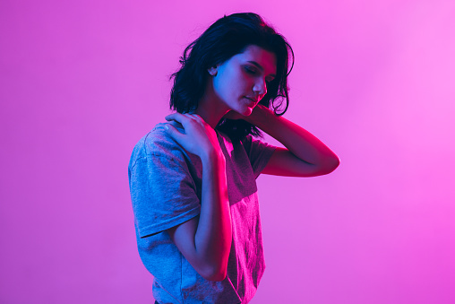 Portrait of beautiful woman. Pink, purple and blue light colors