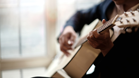 Cropped shot of man practicing in playing acoustic guitar