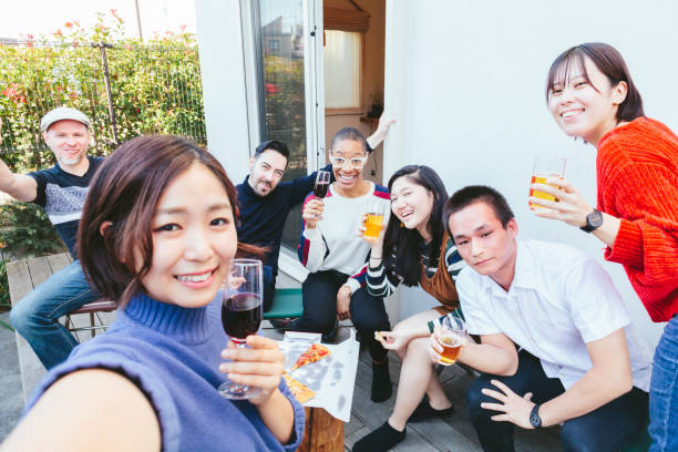 自宅パーティーを楽しんで多民族の友人のグループ - outdoors party social gathering women ストックフォトと画像