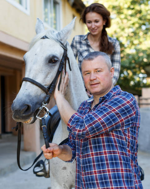 istock Man trainer teach to female while riding horse at ranch 1071422928